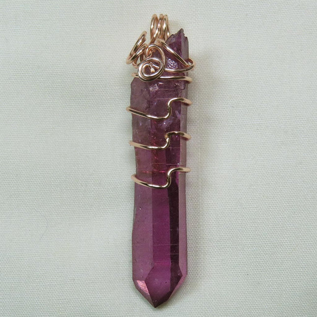 Purple Mist Aura Quartz Crystal Wire Wrapped Pendant Jewelry on a light gray background