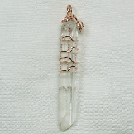 Arkansas Quartz Crystal Point Wire Wrapped Pendant Jewelry on a light gray background