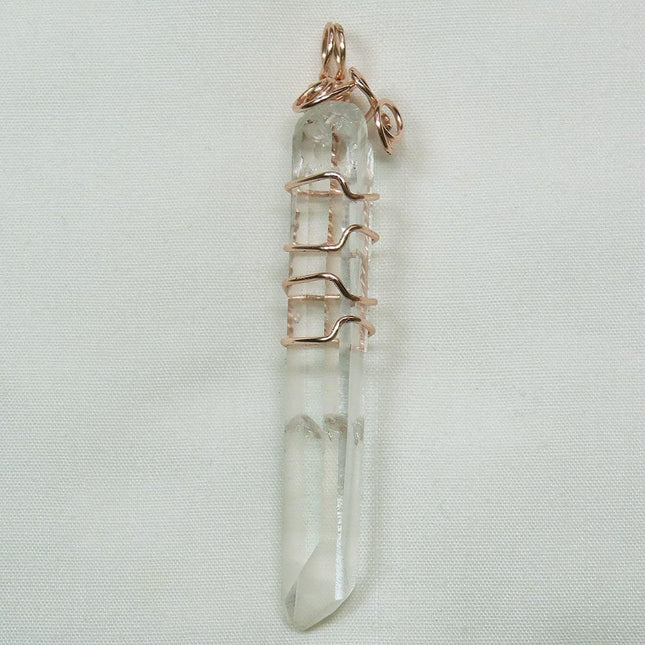 Arkansas Quartz Crystal Point Wire Wrapped Pendant Jewelry on a light gray background