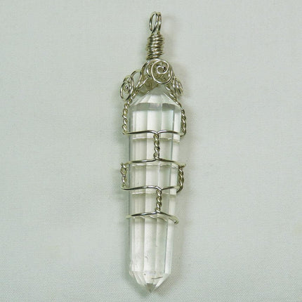 Vogel Quartz Crystal Generator DT from Brazil Wire Wrapped Pendant on a light gray background