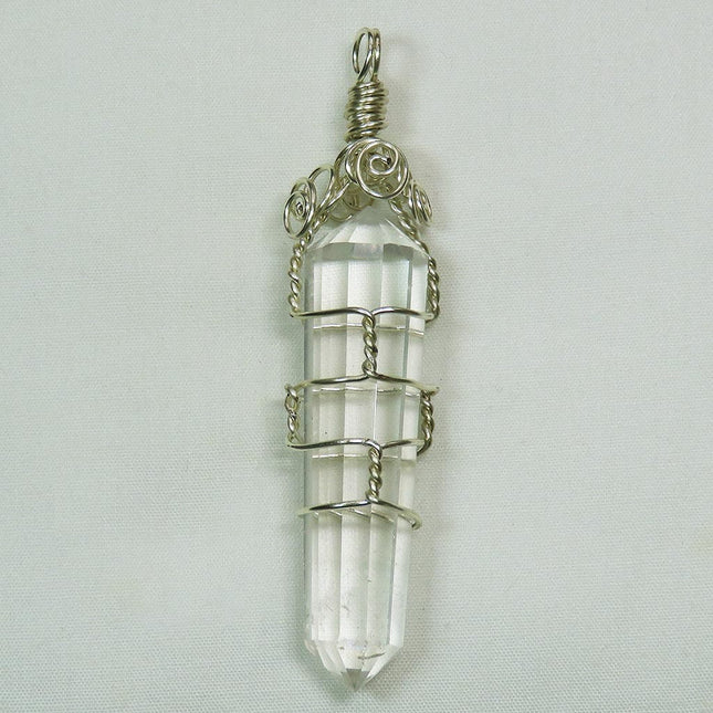 Vogel Quartz Crystal Generator DT from Brazil Wire Wrapped Pendant on a light gray background
