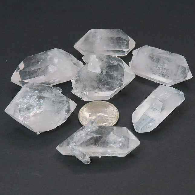 5 Arkansas Quartz Crystal Double Terminated Points & 2 DT/ET Points on a dark surface with a coin for scale