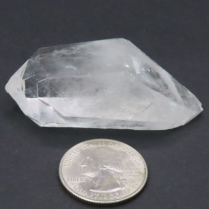 Arkansas Quartz Crystal Double Terminated/ET Point next to a U.S. quarter dollar on a dark background