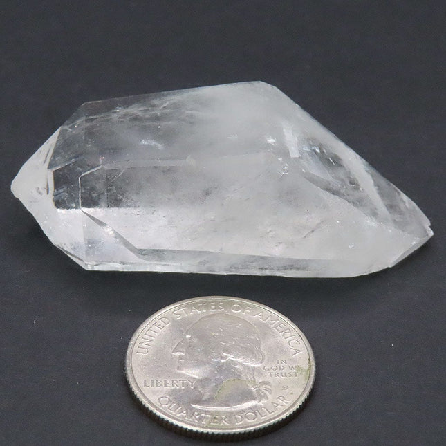 Arkansas Quartz Crystal Double Terminated/ET Point next to a U.S. quarter dollar on a dark background