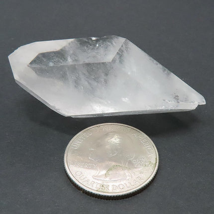 Arkansas Quartz Crystal Double Terminated/ET Point next to a quarter on a dark surface