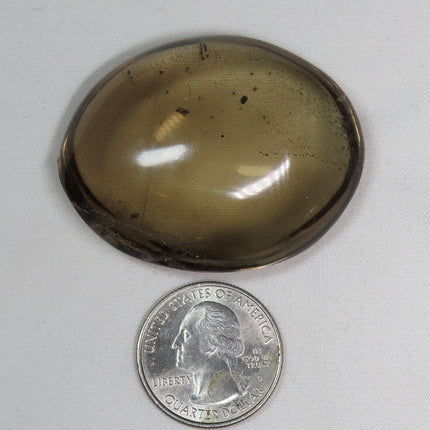 Polished Smoky Quartz Palm Stone from Brazil with Chlorite Included next to a U.S. quarter dollar on a white background
