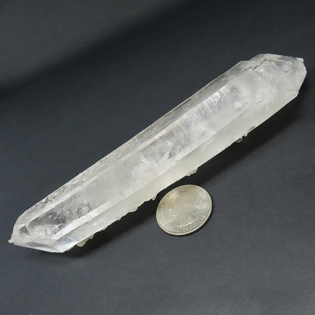Arkansas Metaphysical Delight Quartz Crystal Double Terminated/ET Point with Faden-Line next to a US quarter on a dark gray background