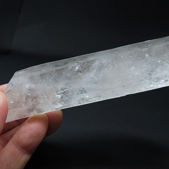 Arkansas Metaphysical Delight Quartz Crystal Double Terminated/ET Point with Faden-Line held by a hand against a black background