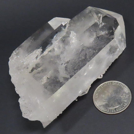 Arkansas Quartz Crystal Tabby Point with Rainbow next to a U.S. quarter for scale on a dark background