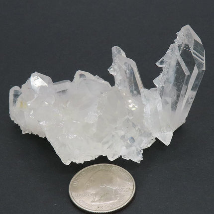 Arkansas Quartz Crystal Burr Cluster with Time-Link Activation and a quarter for scale on a dark background