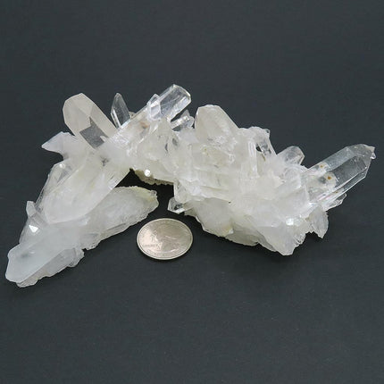 Arkansas Quartz Crystal Cluster with 4" Long DT & Time-Link Activations and a quarter for scale on a dark background