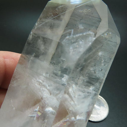 Arkansas Quartz Crystal Point with Record Keeper Triangles next to a US quarter for scale on a dark surface