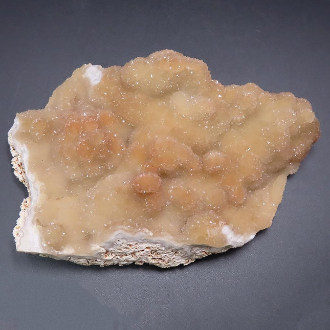 Sparkling Peach Pink Botryoidal Drusy Quartz Specimen from Missouri with a gray background