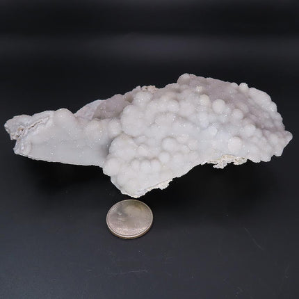 Sparkling Silver Grey Botryoidal Drusy Quartz Specimen from Missouri on a dark background with a quarter for scale on a black background