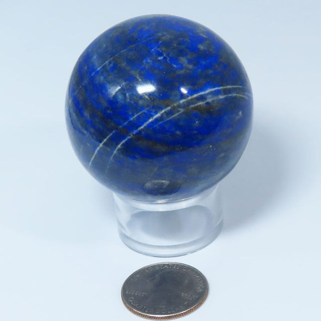 Polished Lapis Sphere Ball from Afghanistan on a clear stand with a quarter for scale on a white background