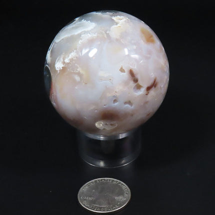 Polished Purple Chalcedony Sphere Ball from Mexico on a stand with a USA quarter for scale against a black background