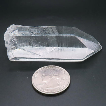 Arkansas Quartz Crystal Point with Record Keeper Triangles with a quarter coin for scale on a dark background