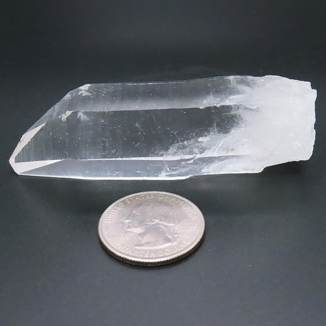 Arkansas Quartz Crystal Point with Time-Link Activation next to a U.S. quarter on a dark background