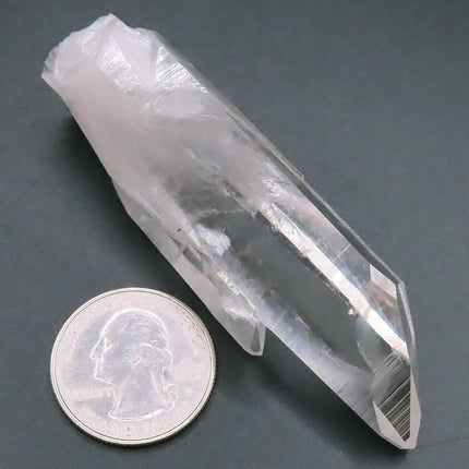 Arkansas Quartz Crystal Point with Time-Link Activation next to a coin on a dark surface