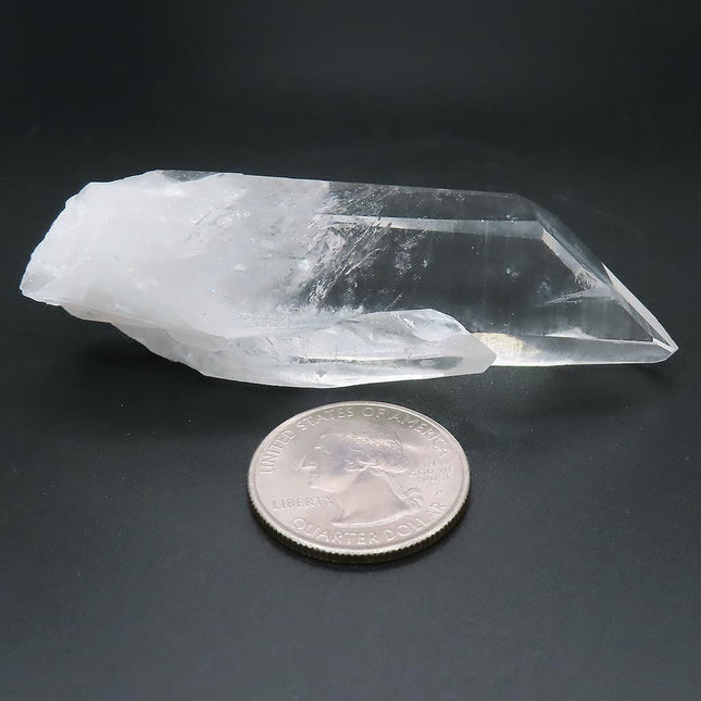 Arkansas Quartz Crystal Point with Time-Link Activation next to a U.S. quarter on a dark background