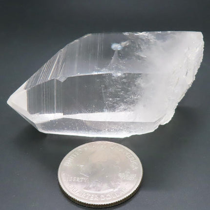 Arkansas Quartz Crystal Point with Window & Self-Healed Base next to a U.S. quarter on a dark background