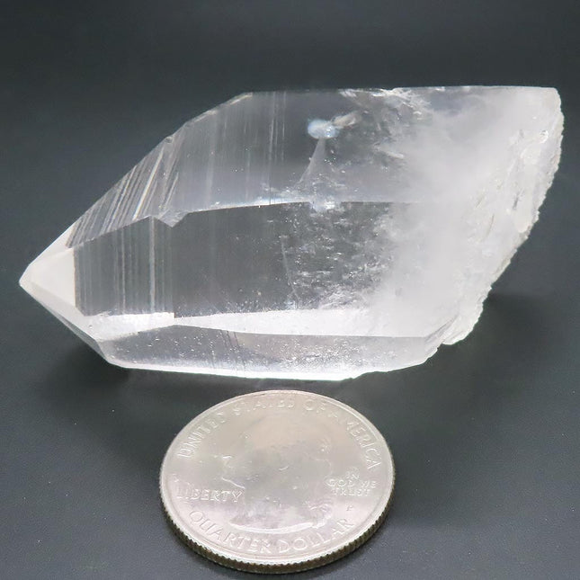 Arkansas Quartz Crystal Point with Window & Self-Healed Base next to a U.S. quarter on a dark background
