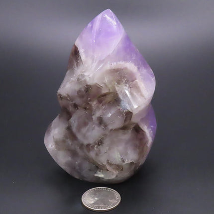 Polished Smoky Amethyst Flame Carving from Madagascar with a quarter for scale on a dark background