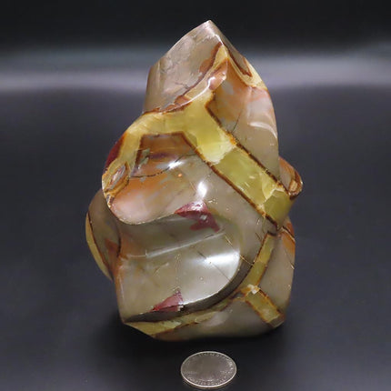 Large Polished Septarian Nodule Flame Carving from Madagascar on a dark background