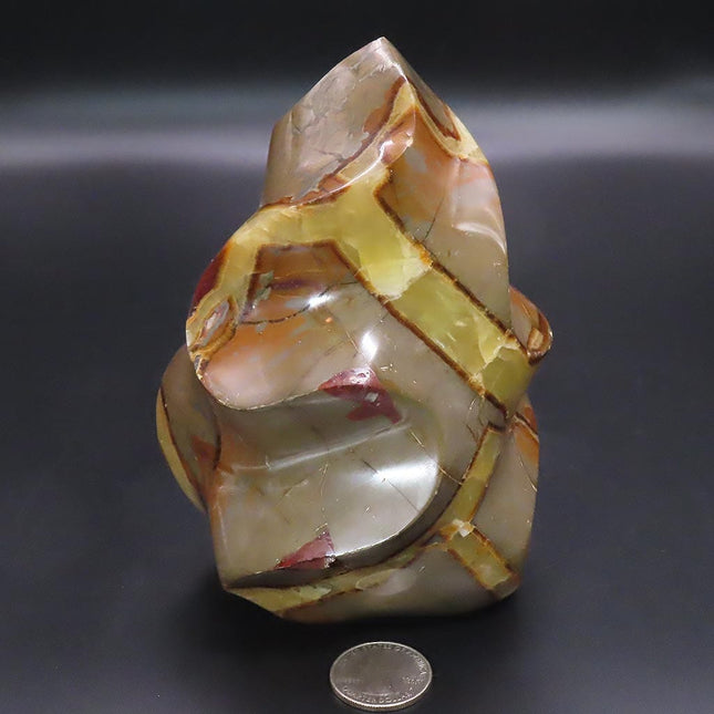 Large Polished Septarian Nodule Flame Carving from Madagascar on a dark background