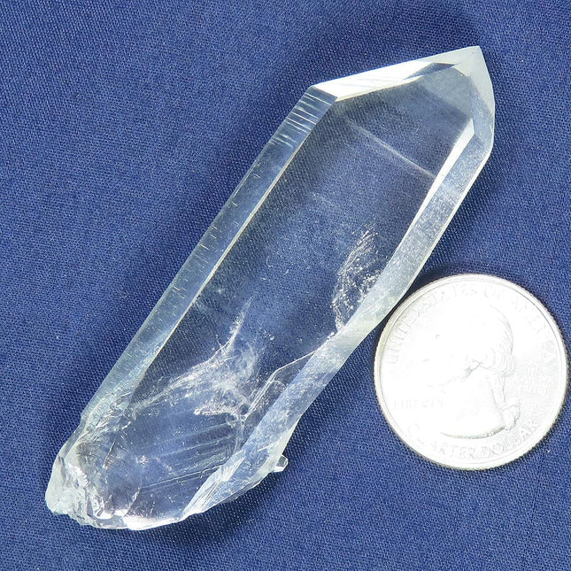 Arkansas Quartz Crystal Tabby Point with Record Keeper Triangles on a blue fabric background with a quarter for scale